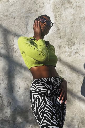 a photo of a woman wearing a green top with zebra pattern pants