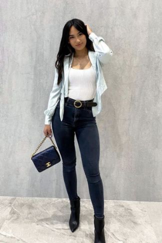 a photo of a woman wearing dark blue jeans and a blue top